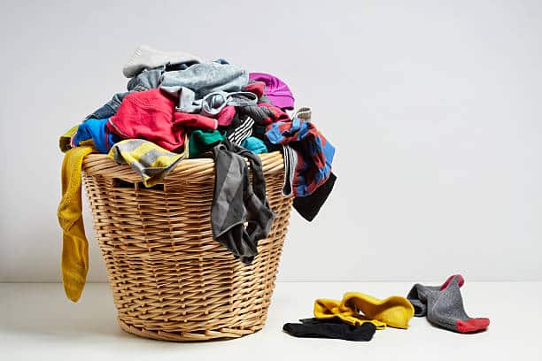 Overflowing laundry basket. Household chore concept on white background